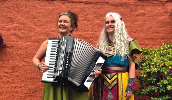 la musicienne Clémence Vandaele et la conteuse Stéphanie Jancar devant un mur aux couleurs de l'Orient